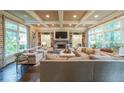 Comfortable living room with large windows, coffered ceilings, built-in shelving, and a stone fireplace at 150 Shady Grove Ln, Alpharetta, GA 30009