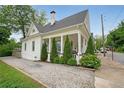 This home features white siding, a gravel driveway, and beautiful greenery around the porch at 224 Bass Sw St, Atlanta, GA 30315