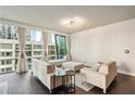 Stylish living area featuring modern furniture, hardwood floors, and large windows at 20 10Th Nw St # 704, Atlanta, GA 30309