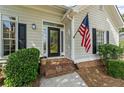 Inviting front entrance with brick steps and American flag at 11155 Highfield Chase Dr, Johns Creek, GA 30097