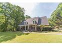 Well-manicured lawn and mature landscaping highlight this home with front porch and dormer windows at 1609 Holly Ridge Dr, Loganville, GA 30052
