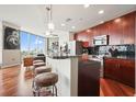 Modern kitchen with a large island, bar seating, stainless steel appliances, and cherry wood cabinets at 400 W Peachtree Nw St # 3801, Atlanta, GA 30308