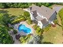 Breathtaking aerial view of a home showcasing a kidney bean-shaped in-ground pool, hot tub, and well-manicured landscaping at 110 Hawks Bnd, Canton, GA 30115