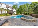 Beautiful backyard featuring an in-ground pool, hot tub, lounge chairs, a covered patio, and lush landscaping at 110 Hawks Bnd, Canton, GA 30115