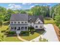 Charming two-story home boasting a welcoming front porch, lush landscaping, and a long driveway on a sunny day at 110 Hawks Bnd, Canton, GA 30115