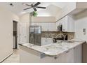 Modern kitchen features stainless steel appliances, granite countertops, white cabinets and a breakfast bar at 15104 Harvest Ridge Ln, Alpharetta, GA 30022