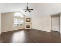 Bright living room featuring a fireplace, large window, hardwood floors, ceiling fan and vaulted ceiling at 15104 Harvest Ridge Ln, Alpharetta, GA 30022