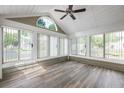 Sunroom with many windows, wood-look flooring and ceiling fan at 15104 Harvest Ridge Ln, Alpharetta, GA 30022