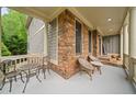 Relaxing front porch with seating, offering a serene view of the landscaped yard at 7505 Antique Barn Ave, Cumming, GA 30041