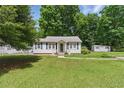Beautiful single-story home with a well-manicured lawn, blue shutters, and a storage shed in the backyard at 8136 Connally Dr, Douglasville, GA 30134