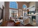 Bright living room features exposed brick, soaring ceilings, large windows, and modern decor with connecting kitchen at 791 Wylie Se St # 912, Atlanta, GA 30316