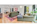 Open living area features an olive green sofa, natural light, colorful rug and hardwood floors at 4060 Haverhill Ne Dr # F, Atlanta, GA 30342