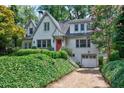 Charming two-story home featuring a driveway, mature trees, and manicured landscaping at 509 Ponce De Leon Pl, Decatur, GA 30030