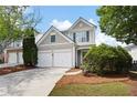 Charming two-story home with a two car garage and manicured landscaping and inviting curb appeal at 212 Regent Sq, Woodstock, GA 30188