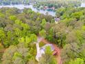 Aerial view of wooded property with home and lake access at 1094 Plantation Ct, Villa Rica, GA 30180