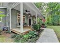 Inviting front porch with seating, ceiling fans, and beautiful landscaping at 4490 Highway 138 Sw, Stockbridge, GA 30281