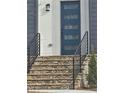 Close-up of a modern front door with stone steps and black railing, offering a stylish entry at 503 Glendale Rd, Scottdale, GA 30079