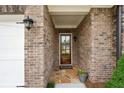 Inviting front entrance with brick surround, stone pavers, and decorative lighting at 5695 Overlook Station Dr, Suwanee, GA 30024