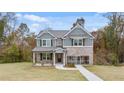 Beautiful two-story home with mixed siding, a covered front porch, and lush green lawn at 115 Maplewood Ln, Conyers, GA 30094
