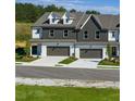 A row of modern townhomes boasts gray and white exteriors with individual driveways at 208 Sharon Ln, Loganville, GA 30052