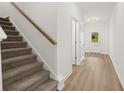 Inviting hallway showcasing a carpeted staircase and durable vinyl flooring at 208 Sharon Ln, Loganville, GA 30052