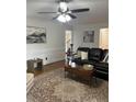 Cozy living room features a ceiling fan, neutral paint, hardwood floors, decorative wainscoting and comfortable seating at 435 Trammell Dr, Alpharetta, GA 30009