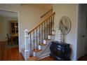Elegant staircase featuring hardwood floors, a decorative chest, and a stylish round mirror at 435 Trammell Dr, Alpharetta, GA 30009
