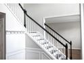 Elegant staircase with white banisters and black handrail, adding a touch of classic charm to the home at 601 Hexham Ct, Suwanee, GA 30024