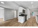 Updated kitchen with white cabinets, black granite counters, modern appliances, and luxury vinyl plank flooring at 2638 Stoney Creek Rd, Marietta, GA 30067