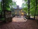 Spacious backyard featuring an outdoor fireplace, stone patio, and expansive deck at 1045 River Pt, Suwanee, GA 30024