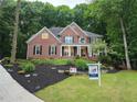 Elegant brick home with lush landscaping, a 'For Sale' sign, and a long driveway at 1045 River Pt, Suwanee, GA 30024