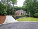 Charming brick home with a well-manicured lawn and lush landscaping at 1045 River Pt, Suwanee, GA 30024