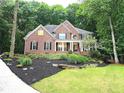 Charming brick home with a well-manicured lawn and lush landscaping at 1045 River Pt, Suwanee, GA 30024