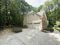 A two car garage and exterior view showing a well-maintained home with a manicured lawn and lush green foliage at 1045 River Pt, Suwanee, GA 30024