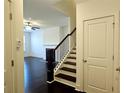 Elegant entryway with dark hardwood floors, staircase with dark wood railing, and neutral paint at 340 Auburn Valley Way, Auburn, GA 30011
