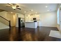 Open-concept kitchen with white cabinets, stainless steel appliances, and hardwood floors at 340 Auburn Valley Way, Auburn, GA 30011