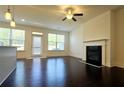 Bright living room with hardwood floors, fireplace, ceiling fan, and large windows at 340 Auburn Valley Way, Auburn, GA 30011