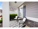 Relaxing porch with black-and-white striped rug, cozy chairs, and manicured greenery at 129 Prominence Ct, Canton, GA 30114