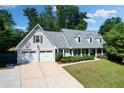 Charming traditional home featuring a two-car garage and inviting front porch with lovely landscaping at 4824 Dunwoody Station Dr, Atlanta, GA 30338