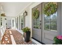 Inviting front porch with brick flooring, potted flowers and front door with decorative wreath at 4824 Dunwoody Station Dr, Atlanta, GA 30338