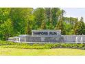 Elegant Champions Run community entrance featuring stone signage, water feature, and landscaping at 8594 Secretariat Dr, Lithonia, GA 30058