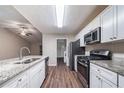 Bright kitchen with stainless steel appliances, granite countertops, and a view of the living area at 5810 Tree Line Ter, Lithonia, GA 30058