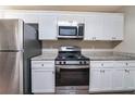 Modern kitchen featuring stainless steel appliances, granite countertops, and white cabinets at 5810 Tree Line Ter, Lithonia, GA 30058