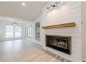 Close-up of a modern fireplace with shiplap accent wall and a rustic wooden mantel at 9985 Lake Forest Way, Roswell, GA 30076