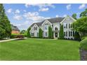 Charming two-story home featuring a lush green lawn, mature trees, and elegant architectural details at 110 Keswick Way, Alpharetta, GA 30022