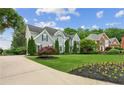 A beautiful home with landscaped lawn, flowering plants and a winding driveway at 110 Keswick Way, Alpharetta, GA 30022