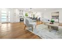 Open-concept living room with hardwood floors and a modern kitchen with white cabinetry in the background at 2813 Hillside Rd, Smyrna, GA 30080