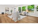 Bright living room featuring hardwood floors, a neutral color palette, and large windows with a lush green view at 2813 Hillside Rd, Smyrna, GA 30080