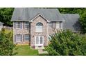 Two-story brick home with grey shutters and gabled entrance is surrounded by mature trees at 5857 Cobalt Dr, Powder Springs, GA 30127