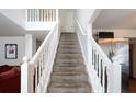 Carpeted staircase with white wood banister leads to the second floor, with views to stainless fridge at 5857 Cobalt Dr, Powder Springs, GA 30127